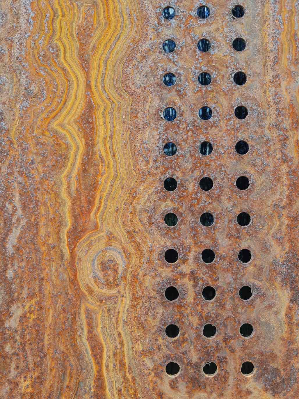 What was once metal is brown and yellow with swirls of bark-like rust.